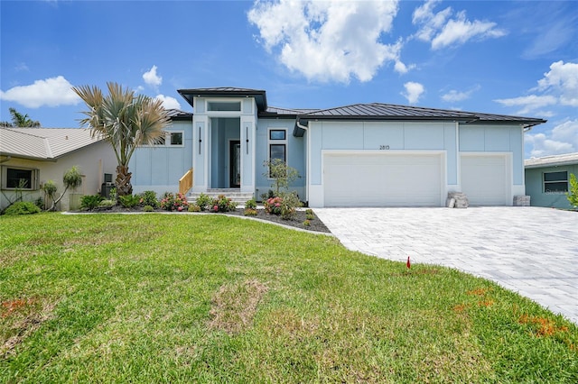 2815 Coral Way, Punta Gorda, FL 33950 - prairie-style house with a standing seam roof, stucco siding, a garage, decorative driveway, and a front lawn
