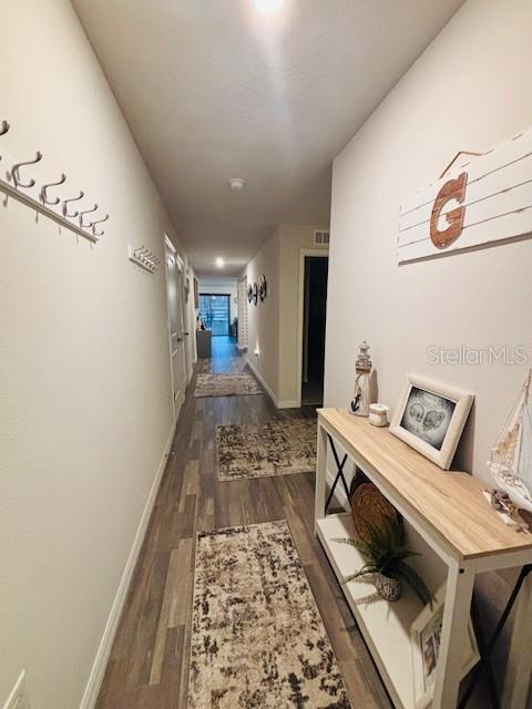6766 N Pavilion Loop, Citrus Springs, FL 34433 - hallway with dark wood-style floors and baseboards