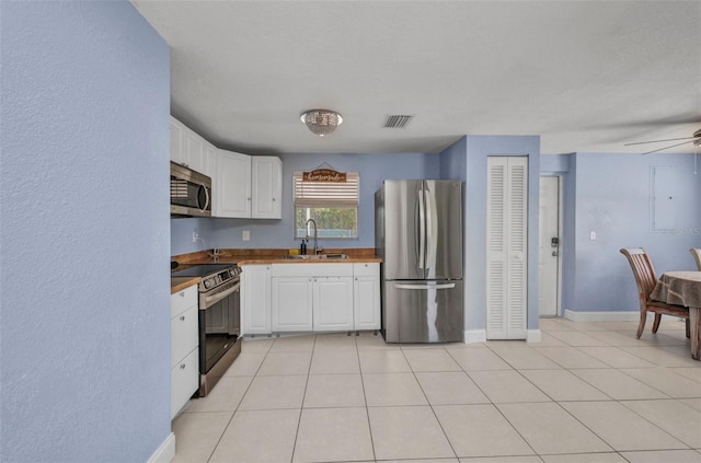 25082 Harborview Rd, Punta Gorda, FL 33980 - kitchen featuring stainless steel appliances, white cabinets, light tile patterned flooring, and ceiling fan