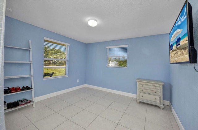 25082 Harborview Rd, Punta Gorda, FL 33980 - empty room with healthy amount of natural light, light tile patterned floors, and a textured ceiling