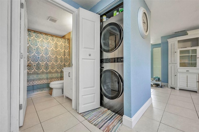 25082 Harborview Rd, Punta Gorda, FL 33980 - bathroom with stacked washing machine and dryer, tile patterned flooring, and curtained shower