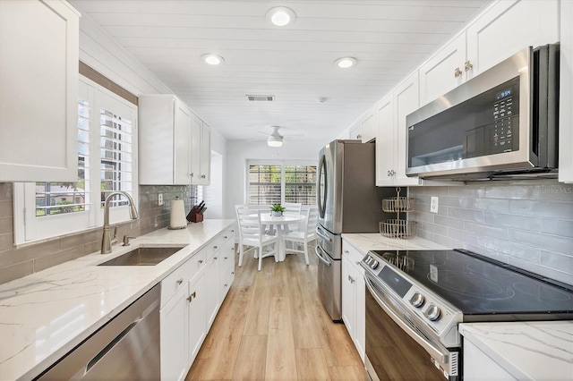 23465 Harborview Rd Unit 1031, Punta Gorda, FL 33980 - kitchen featuring stainless steel appliances, white cabinets, recessed lighting, light wood finished floors, and backsplash