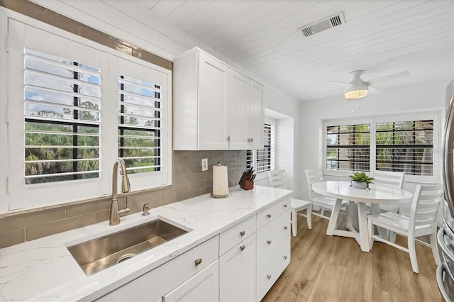 23465 Harborview Rd Unit 1031, Punta Gorda, FL 33980 - kitchen featuring tasteful backsplash, light wood-style flooring, white cabinetry, light stone countertops, and wooden ceiling