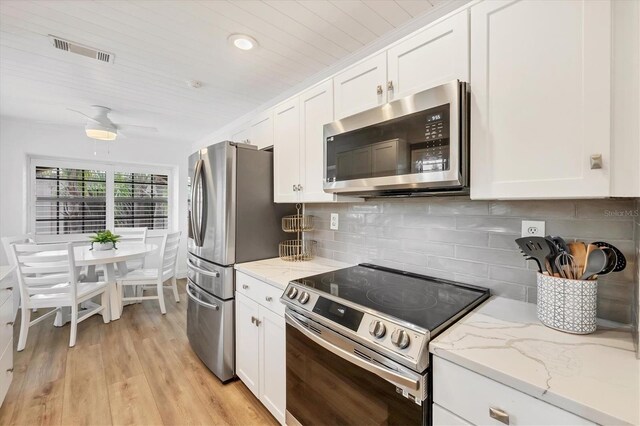 23465 Harborview Rd Unit 1031, Punta Gorda, FL 33980 - kitchen featuring appliances with stainless steel finishes, white cabinets, light stone countertops, light wood-style flooring, and wood ceiling