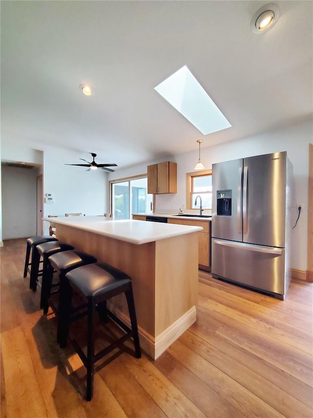 3456 Highlands Rd, Punta Gorda, FL 33983 - kitchen featuring stainless steel refrigerator with ice dispenser, a skylight, light wood-style floors, light countertops, and recessed lighting