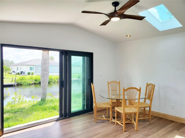 3456 Highlands Rd, Punta Gorda, FL 33983 - dining space with a water view, a skylight, wood finished floors, vaulted ceiling, and a ceiling fan