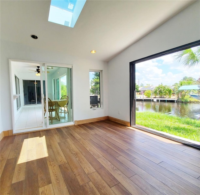 3456 Highlands Rd, Punta Gorda, FL 33983 - unfurnished living room featuring a water view, vaulted ceiling, wood finished floors, a skylight, and recessed lighting