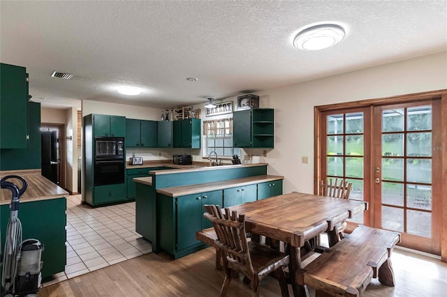 2788 SW County Road 769, Arcadia, FL 34266 - kitchen featuring green cabinetry, a peninsula, refrigerator, a textured ceiling, and open shelves