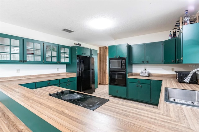 2788 SW County Road 769, Arcadia, FL 34266 - kitchen featuring black appliances, light countertops, glass insert cabinets, and a textured ceiling