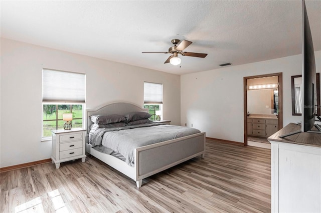 2788 SW County Road 769, Arcadia, FL 34266 - bedroom featuring light wood-style flooring, ensuite bathroom, ceiling fan, and a textured ceiling