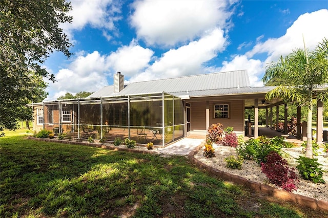2788 SW County Road 769, Arcadia, FL 34266 - rear view of house featuring a chimney, a lawn, ceiling fan, a lanai, and a metal roof