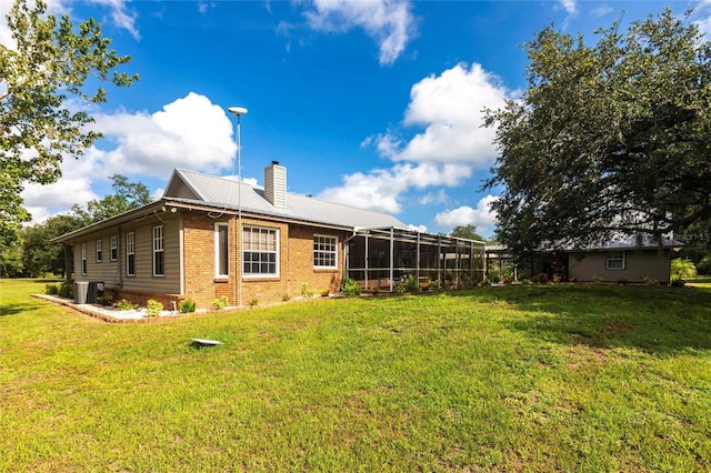2788 SW County Road 769, Arcadia, FL 34266 - rear view of house with brick siding, a chimney, a yard, and a metal roof