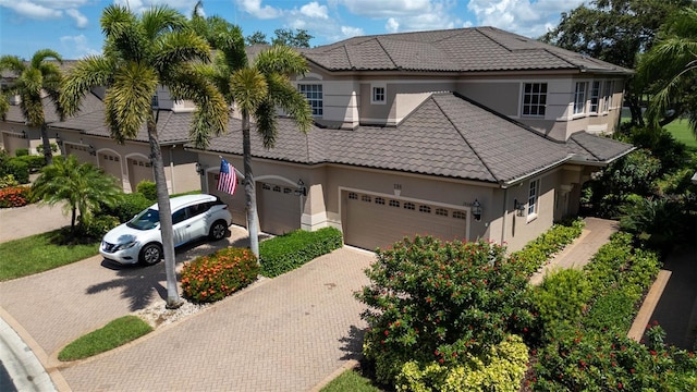 786 Regency Reserve Cir Unit 1404, Naples, FL 34119 - mediterranean / spanish-style home featuring decorative driveway, stucco siding, a tile roof, and an attached garage