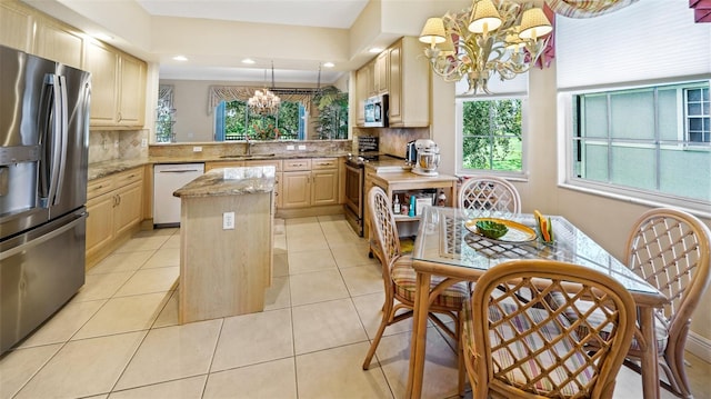 786 Regency Reserve Cir Unit 1404, Naples, FL 34119 - kitchen featuring appliances with stainless steel finishes, a chandelier, light brown cabinetry, a kitchen island, and backsplash