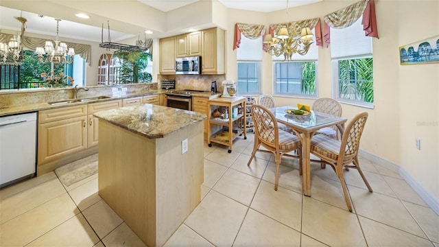 786 Regency Reserve Cir Unit 1404, Naples, FL 34119 - kitchen with a chandelier, appliances with stainless steel finishes, light stone counters, a center island, and tasteful backsplash
