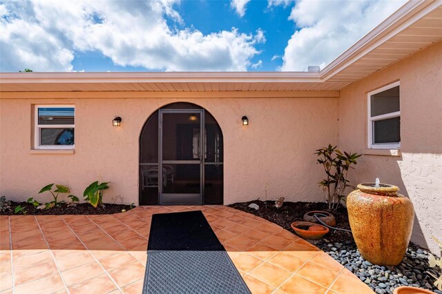 10810 Wheeler Pl, Punta Gorda, FL 33950 - doorway to property with stucco siding and a patio area