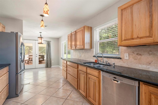 10810 Wheeler Pl, Punta Gorda, FL 33950 - kitchen with appliances with stainless steel finishes, tasteful backsplash, light tile patterned floors, hanging light fixtures, and dark stone countertops