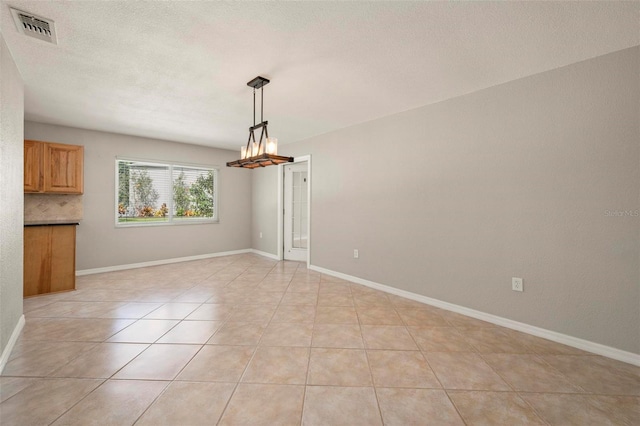10810 Wheeler Pl, Punta Gorda, FL 33950 - unfurnished dining area with a chandelier, light tile patterned floors, and a textured ceiling