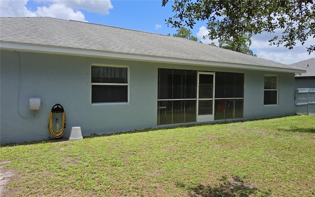 6341 Opa Locka Ln, North Port, FL 34291 - rear view of house featuring a lawn, stucco siding, and roof with shingles