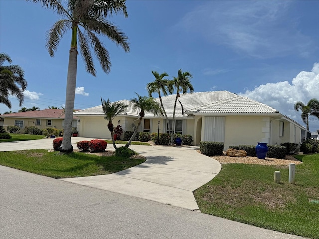 1128 Rum Cay Ct, Punta Gorda, FL 33950 - ranch-style house with curved driveway, a tile roof, a garage, and a front lawn