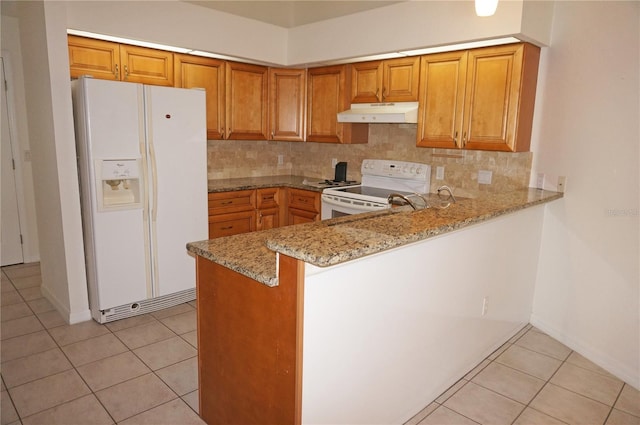 1128 Rum Cay Ct, Punta Gorda, FL 33950 - kitchen with white appliances, under cabinet range hood, light stone countertops, light tile patterned flooring, and decorative backsplash