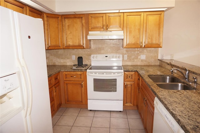 1128 Rum Cay Ct, Punta Gorda, FL 33950 - kitchen with white appliances, under cabinet range hood, brown cabinetry, light tile patterned floors, and stone counters