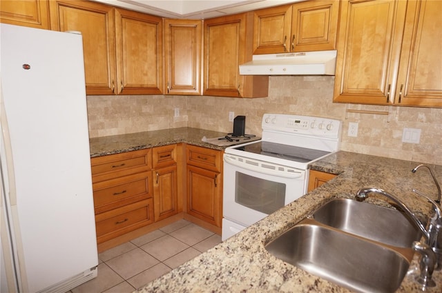 1128 Rum Cay Ct, Punta Gorda, FL 33950 - kitchen with white appliances, under cabinet range hood, brown cabinets, and light tile patterned floors