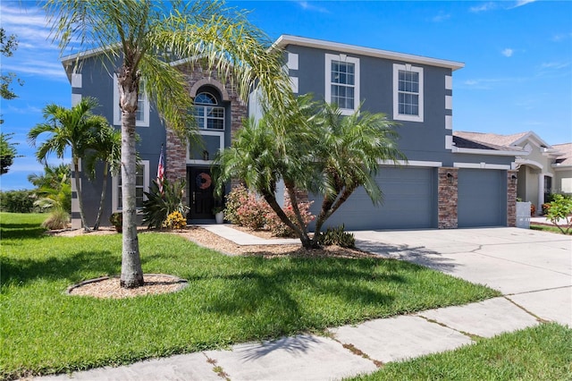 2736 Suncoast Lakes Blvd, Punta Gorda, FL 33980 - view of front facade featuring concrete driveway, a front yard, a garage, and stucco siding