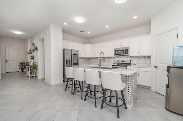 24348 Nicobar Ln, Punta Gorda, FL 33955 - kitchen with stainless steel appliances, a breakfast bar, backsplash, light countertops, and white cabinetry