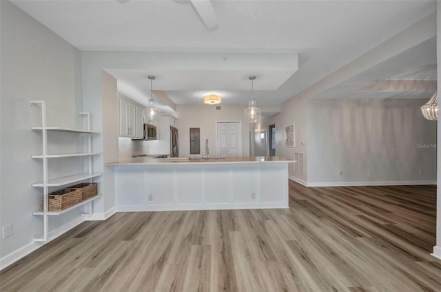 900 E Marion Ave Unit 1203, Punta Gorda, FL 33950 - kitchen featuring light wood finished floors, a peninsula, open floor plan, white cabinetry, and light countertops