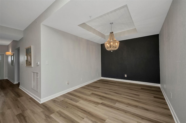 900 E Marion Ave Unit 1203, Punta Gorda, FL 33950 - spare room with a chandelier, wood finished floors, and a tray ceiling