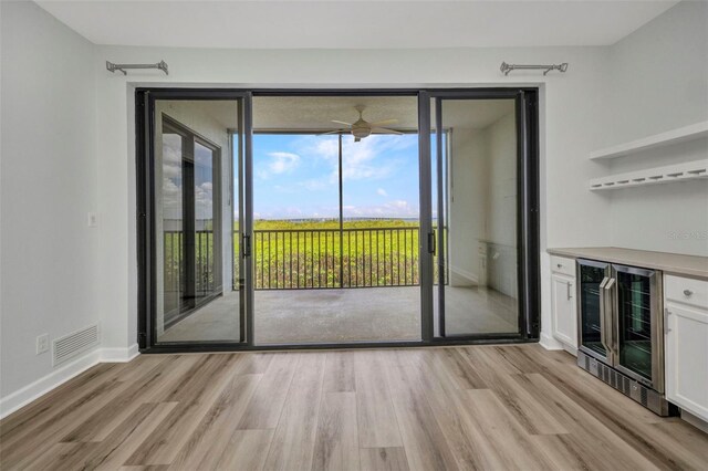 900 E Marion Ave Unit 1203, Punta Gorda, FL 33950 - unfurnished dining area with wine cooler, light wood-type flooring, ceiling fan, and a bar