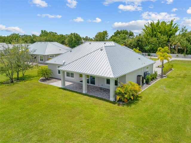 28960 Gin Ln, Punta Gorda, FL 33982 - rear view of property featuring stucco siding, a patio area, a standing seam roof, a lawn, and a metal roof