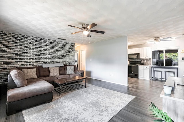 8513 Heister St, Punta Gorda, FL 33982 - living area with a ceiling fan, dark wood finished floors, and brick wall