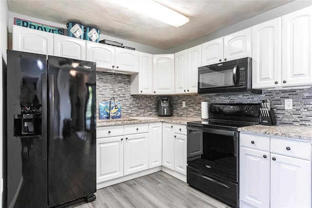8513 Heister St, Punta Gorda, FL 33982 - kitchen featuring black appliances, light wood-style flooring, and white cabinets