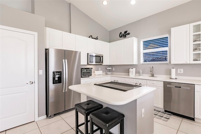 2105 Deborah Dr, Punta Gorda, FL 33950 - kitchen with appliances with stainless steel finishes, light tile patterned flooring, a kitchen island, white cabinets, and recessed lighting