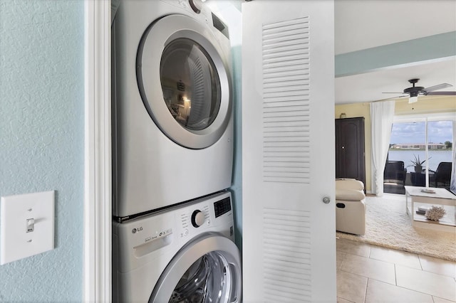 26310 Rampart Blvd Unit 504, Punta Gorda, FL 33983 - washroom with stacked washing machine and dryer, ceiling fan, tile patterned floors, and a textured wall