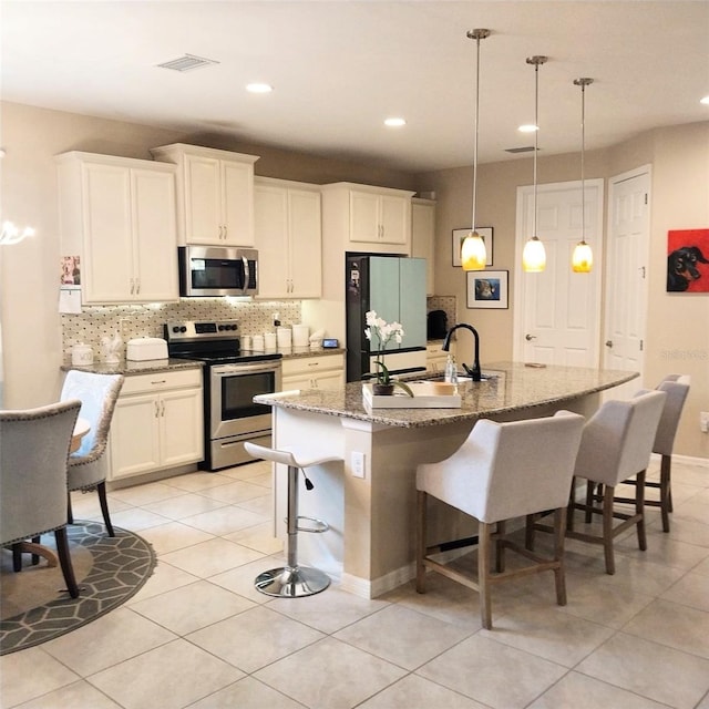 25224 Lahore Ln, Punta Gorda, FL 33983 - kitchen featuring stainless steel appliances, decorative backsplash, a kitchen breakfast bar, light tile patterned flooring, and recessed lighting