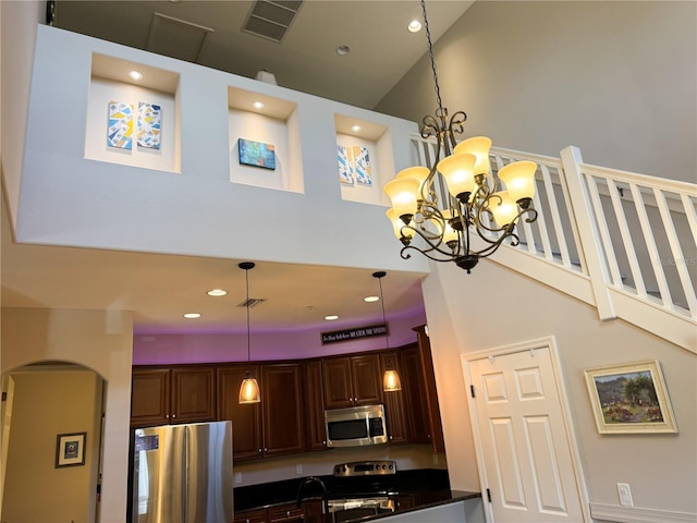 11220 Paseo Grande Blvd Unit 5207, Fort Myers, FL 33912 - kitchen with appliances with stainless steel finishes, high vaulted ceiling, dark countertops, a chandelier, and recessed lighting