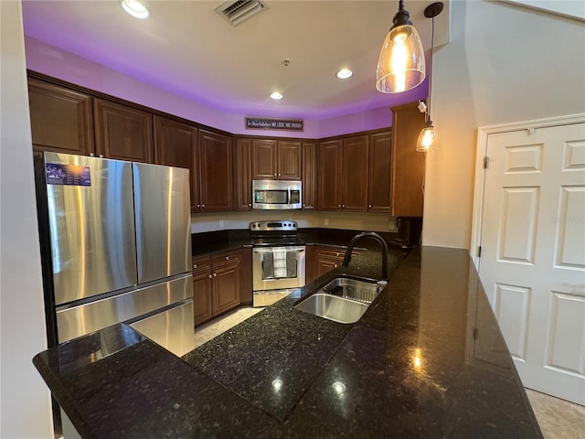 11220 Paseo Grande Blvd Unit 5207, Fort Myers, FL 33912 - kitchen featuring appliances with stainless steel finishes, recessed lighting, pendant lighting, dark stone counters, and a peninsula