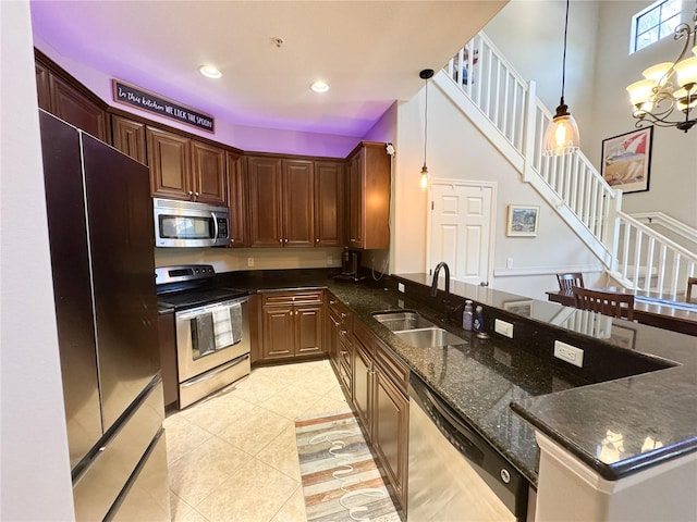 11220 Paseo Grande Blvd Unit 5207, Fort Myers, FL 33912 - kitchen featuring appliances with stainless steel finishes, light tile patterned flooring, pendant lighting, dark stone counters, and a chandelier