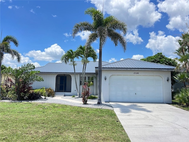 2526 Brazilia Ct, Punta Gorda, FL 33950 - ranch-style house featuring an attached garage, a front lawn, driveway, stucco siding, and a metal roof