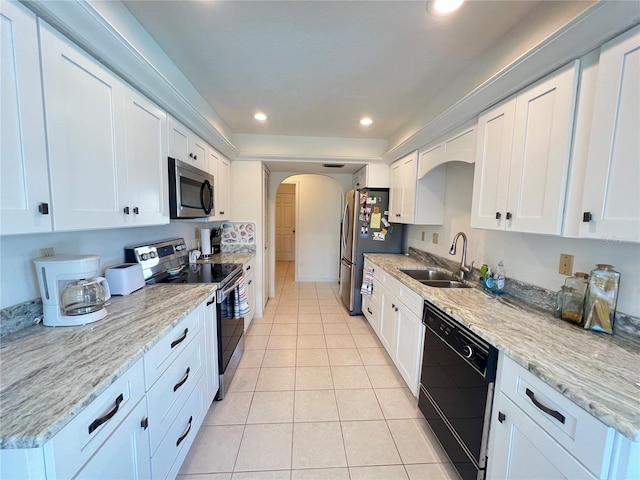 2526 Brazilia Ct, Punta Gorda, FL 33950 - kitchen with appliances with stainless steel finishes, light tile patterned flooring, arched walkways, white cabinetry, and recessed lighting