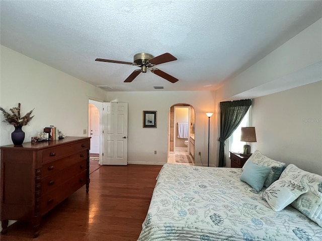 2526 Brazilia Ct, Punta Gorda, FL 33950 - bedroom featuring dark wood-style flooring, arched walkways, ensuite bathroom, ceiling fan, and a textured ceiling