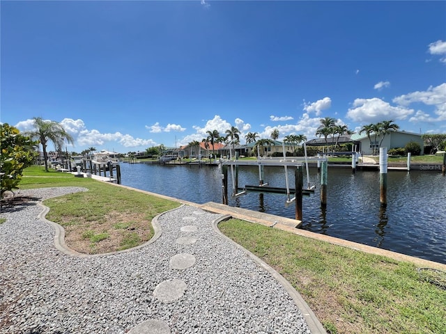 2526 Brazilia Ct, Punta Gorda, FL 33950 - dock area featuring boat lift, a water view, a yard, and a residential view