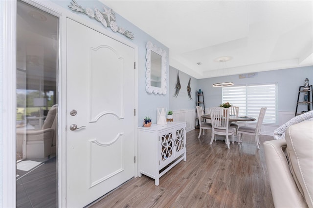 26254 Stillwater Cir, Punta Gorda, FL 33955 - entryway with wainscoting, a raised ceiling, and light wood finished floors