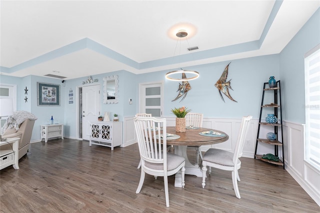 26254 Stillwater Cir, Punta Gorda, FL 33955 - dining space with a tray ceiling, wood finished floors, wainscoting, and a decorative wall
