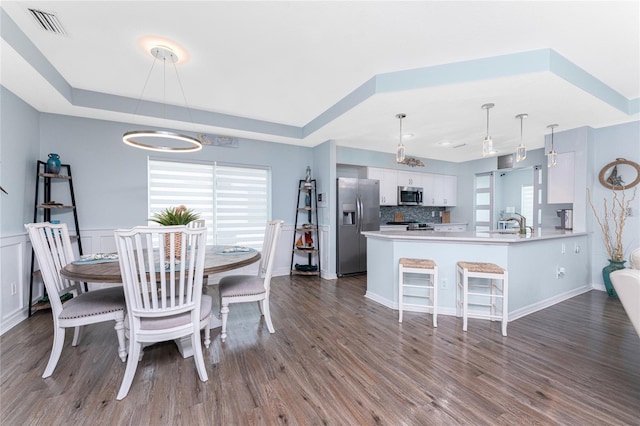 26254 Stillwater Cir, Punta Gorda, FL 33955 - dining space featuring a raised ceiling, plenty of natural light, and dark wood finished floors