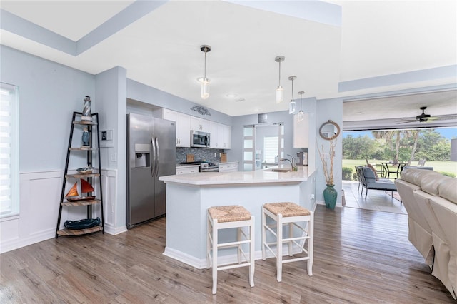 26254 Stillwater Cir, Punta Gorda, FL 33955 - kitchen with stainless steel appliances, open floor plan, light wood-style floors, and white cabinets