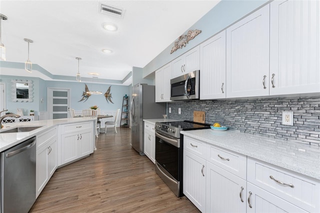 26254 Stillwater Cir, Punta Gorda, FL 33955 - kitchen with stainless steel appliances, white cabinetry, pendant lighting, backsplash, and recessed lighting